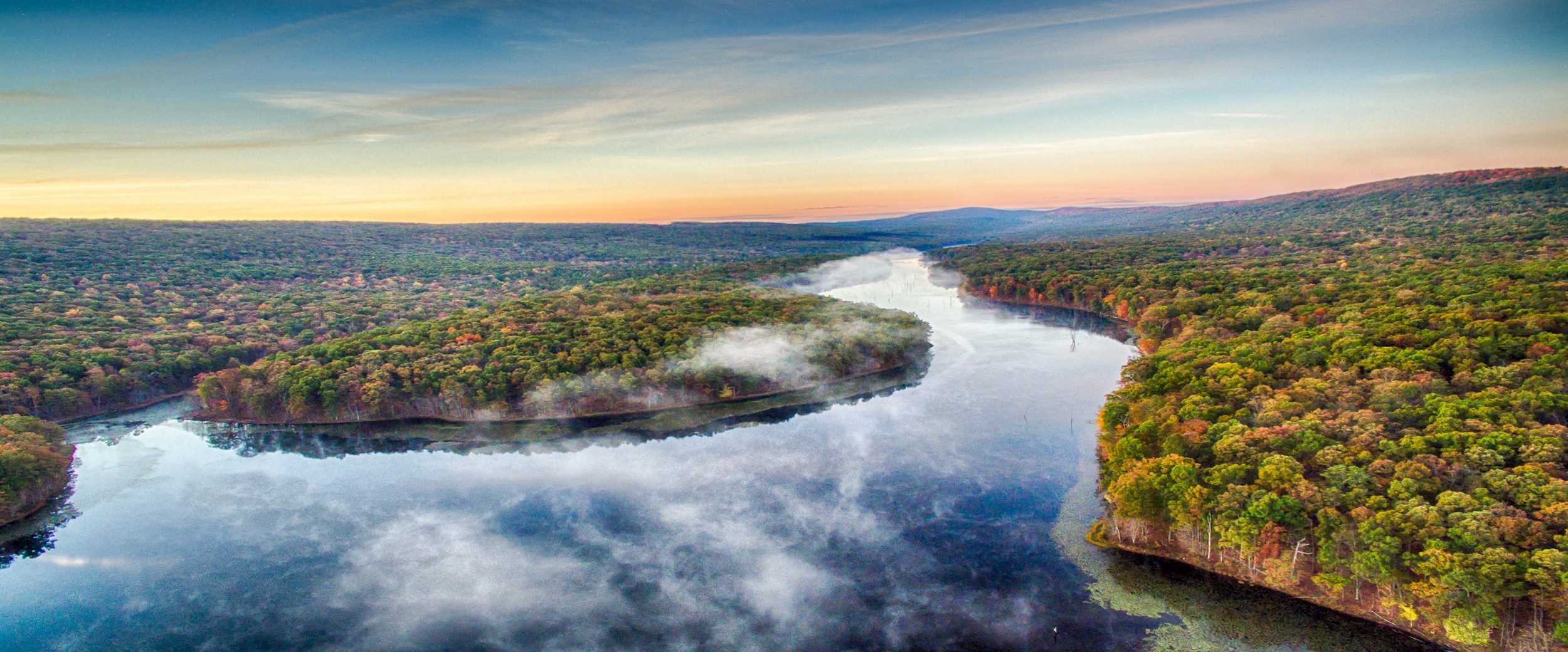 Sleepy Creek Lake surrounded by autumn forest at sunrise