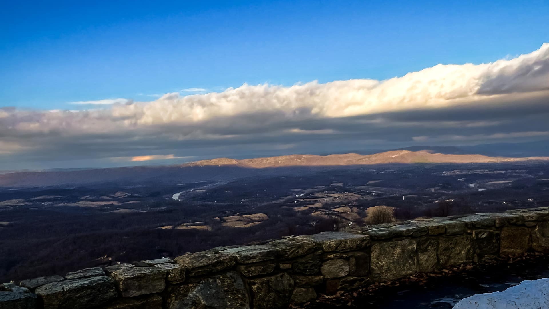 Snow along the stone wall of a Skyline Drive overlook above the Shenandoah Valley in February