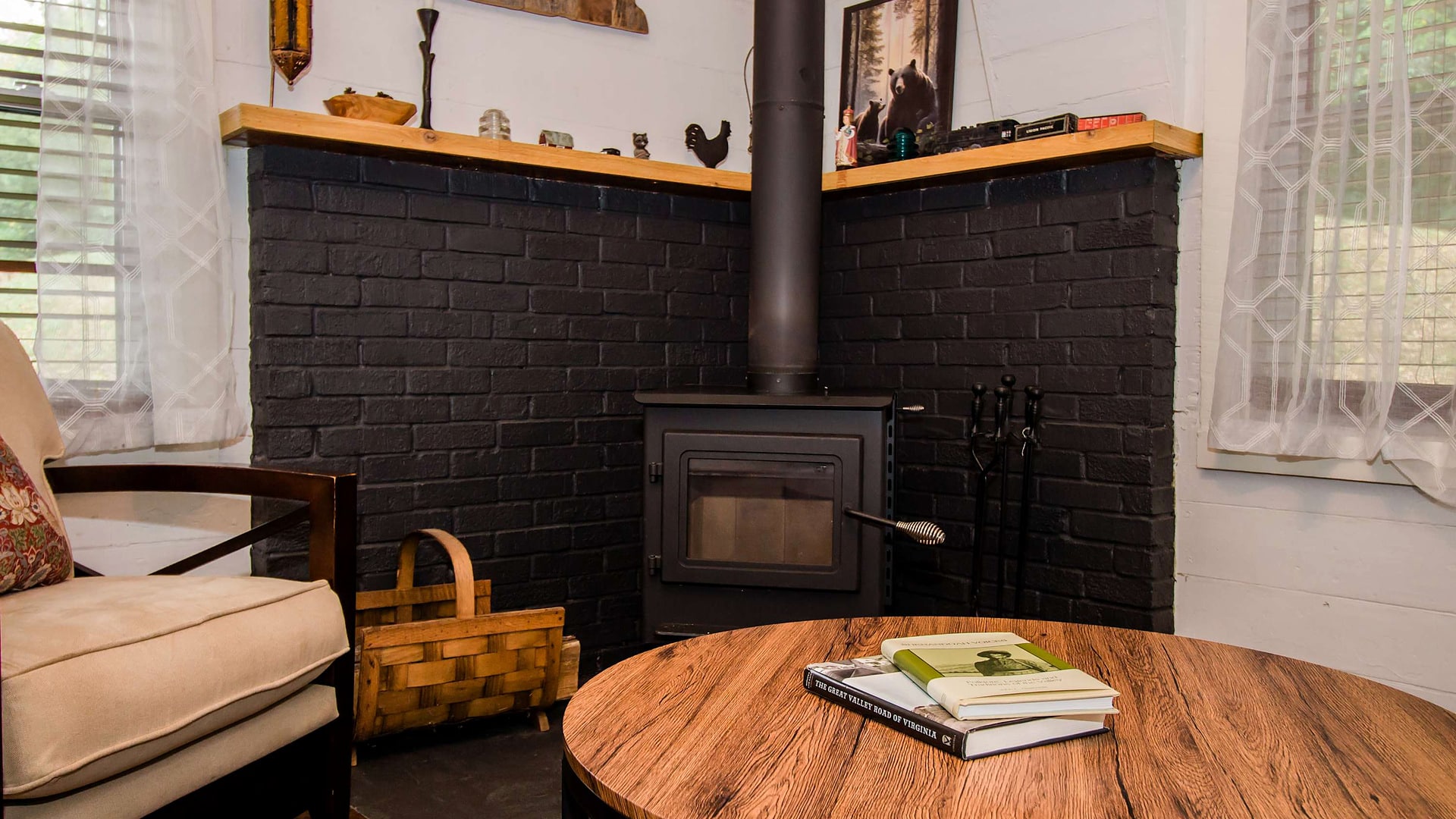 Wood-burning stove and reading table at Black Bear Vista, a Blue Maple home near Bryce Resort, Virginia