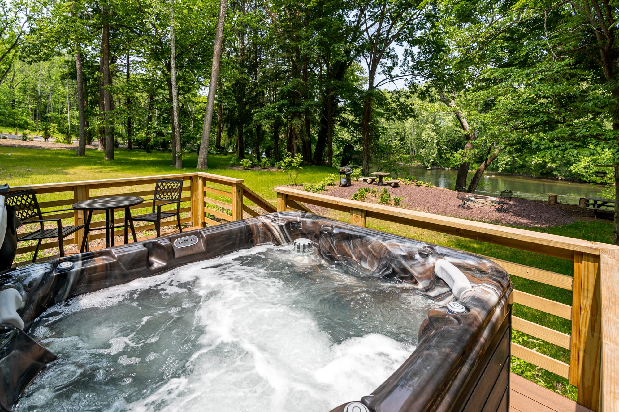 Private hot tub on a riverside deck with the Shenandoah River behind it