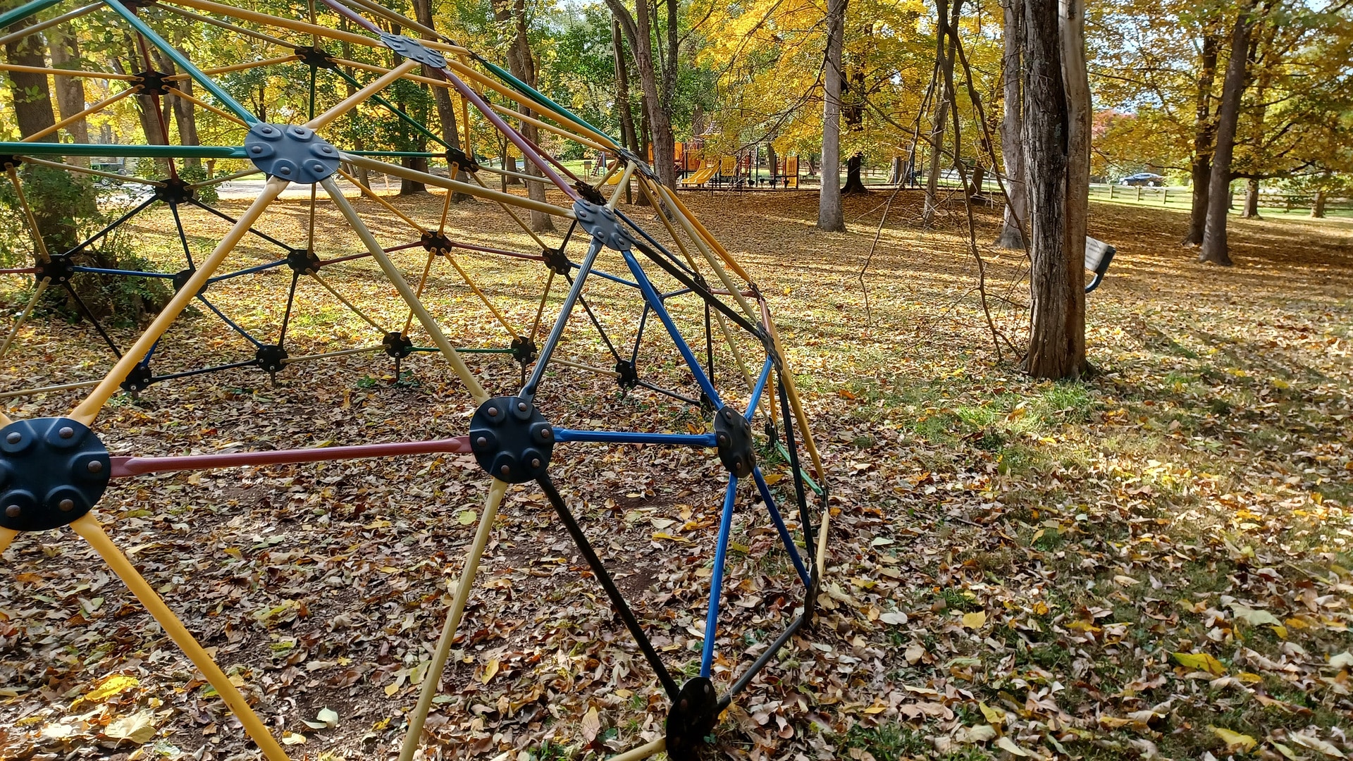 Fallen autumn leaves around the playground climbing dome at Morgan's Grove Park in Shepherdstown