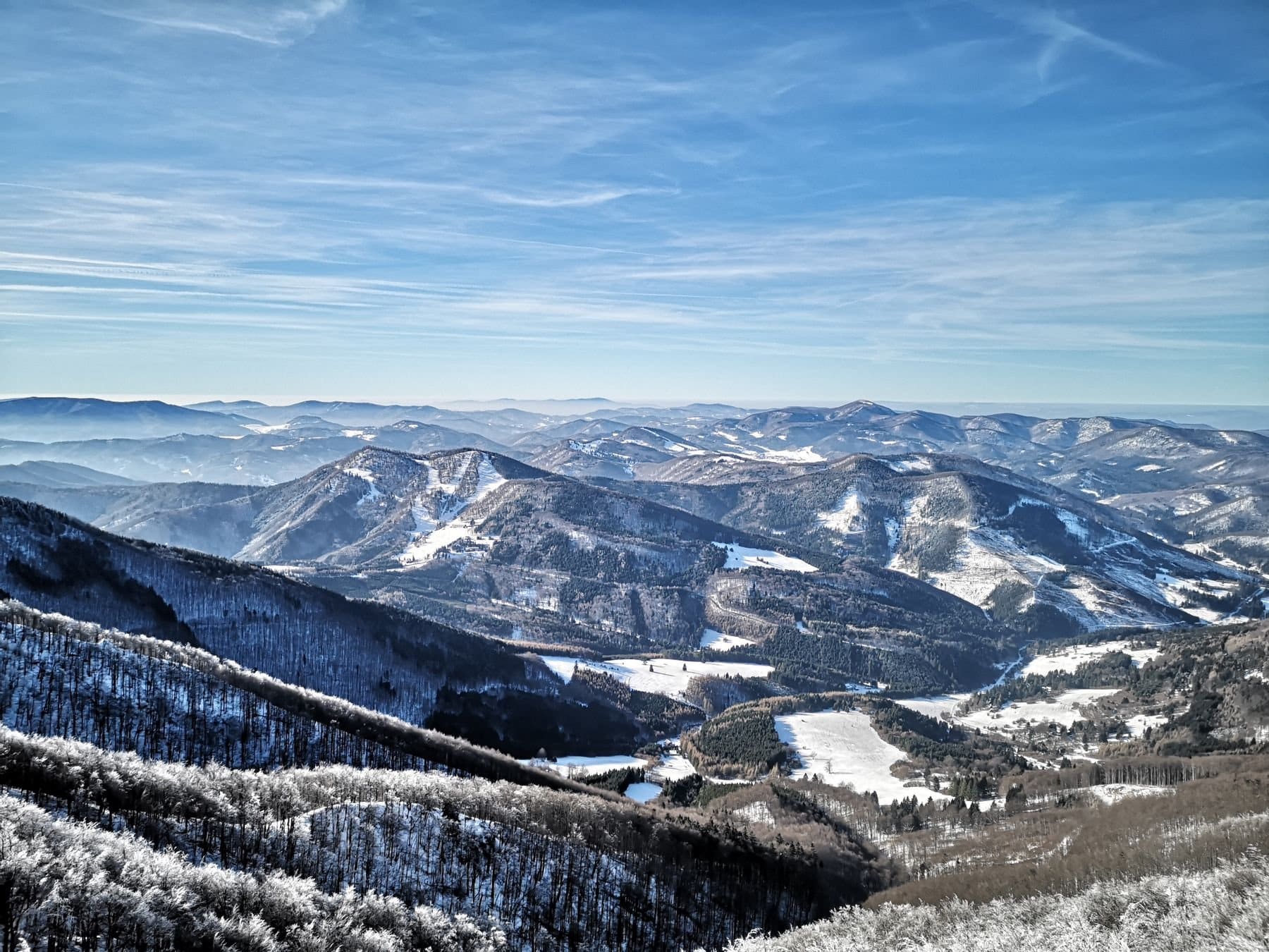 Snow-dusted mountain ridges under a clear winter sky