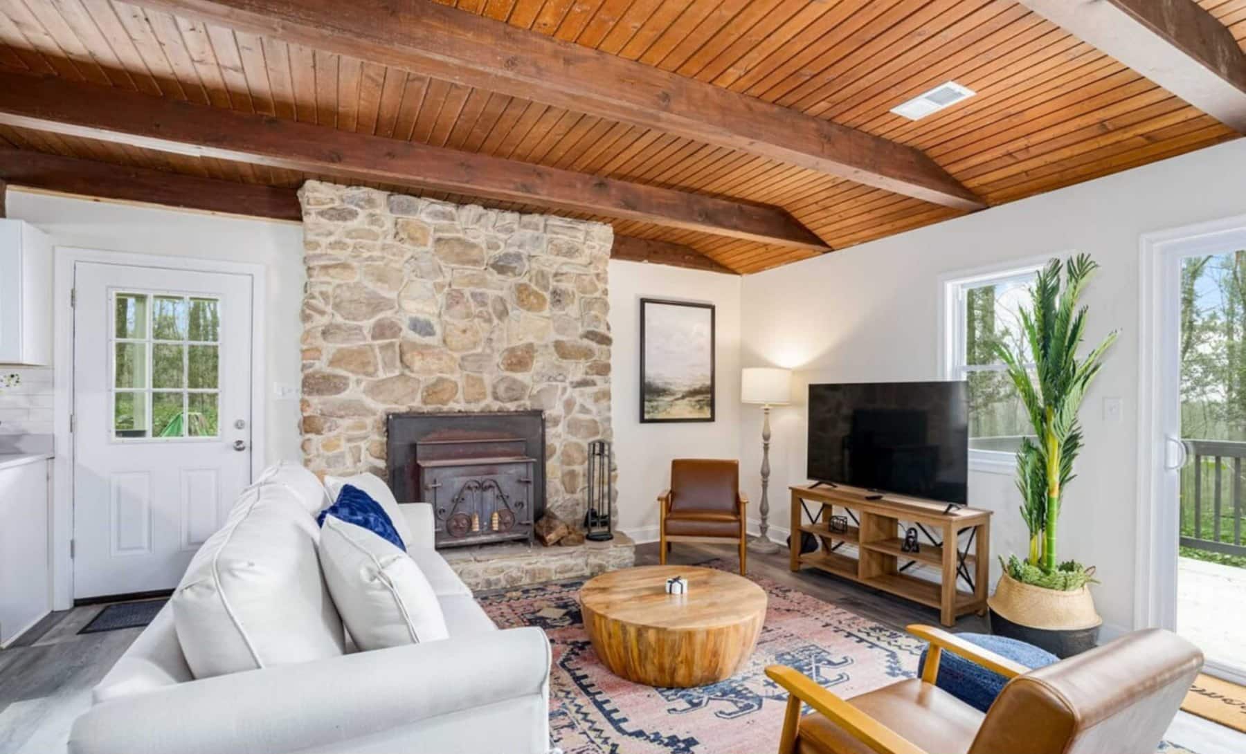 Living room with a stone fireplace at Wildwood Chalet, a Blue Maple cabin